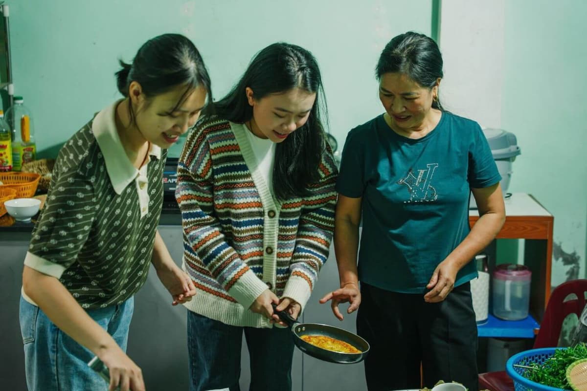 Travellers join a cooking experience and prepare local specialties under the guidance of local homemakers
